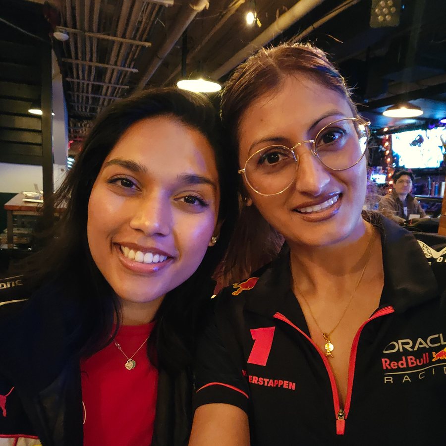 Two friends on race day, one in Ferrari red, one in a Red Bull Racing team shirt